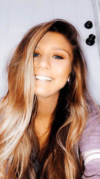 Smiling woman with long hair indoors.