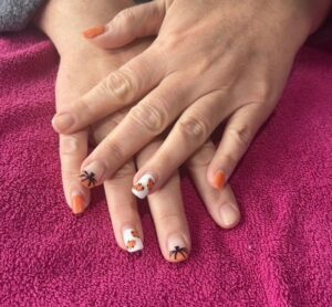 Hands with Halloween-themed nail art.