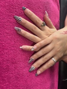 Hands with black and white nail art.