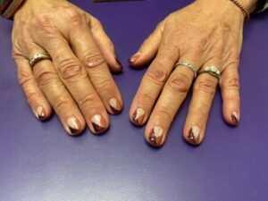 Hands with geometric nail art and rings.