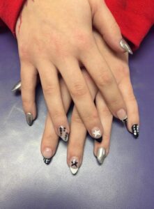 Hands with artistic silver and black nails.
