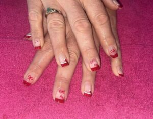 Festive nails with red tips and designs.