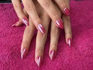 Hands with pink metallic nail polish.