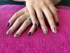 Hands with multicolored manicured nails displayed.