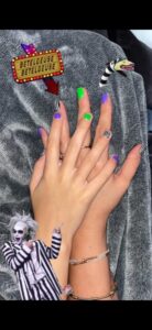 Hands with colorful nails and Beetlejuice theme.